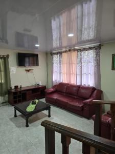 a living room with a red couch and a table at Hostal Las Molas in Volcán