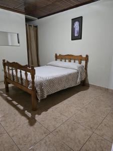a bedroom with a wooden bed in a room at Hostal Las Molas in Volcán