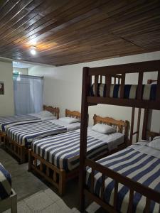 a room with three bunk beds in a room at Hostal Las Molas in Volcán