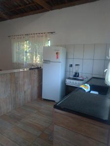 a kitchen with a white refrigerator and a stove at Bella Serra in Iporanga