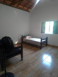a bedroom with a bed and a chair in a room at Bella Serra in Iporanga