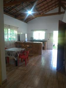 a living room with a table and a kitchen at Bella Serra in Iporanga