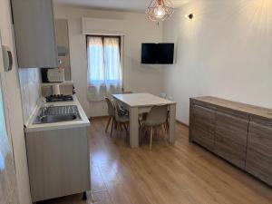 a kitchen with a table and a small kitchen with a sink at Casa D'Agostino in Cortona +7 photos