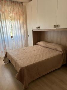 a bedroom with a bed and a window and cabinets at Casa D'Agostino in Cortona
