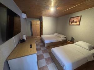 a hotel room with two beds and a television at okuninkanoclegi in Okuninka +40 photos