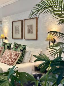 a living room with a couch and some plants at Pepper Tree Venue & Guesthouse in Bloemfontein