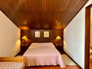 a bed in a room with a wooden ceiling at Casa de praia com piscina in Árvore +27 photos