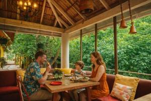 a family sitting at a table in a restaurant at Casa Do Leão - Heritage Boutique Stay in Nerul
