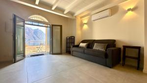 a living room with a couch and a large window at Appartamento Zu fronte lago con piscina in Fonteno
