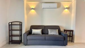 a blue couch sitting in a living room with two pillows at Appartamento Zu fronte lago con piscina in Fonteno