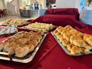 a table topped with trays of bread and pastries at San Miguel Plaza Hotel All Inclusive in Villa San Miguel