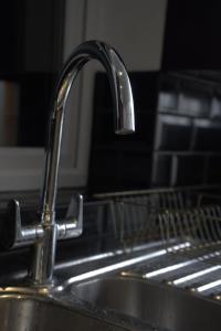 a sink in a kitchen with a faucet at The Bank in West Derby +59 photos