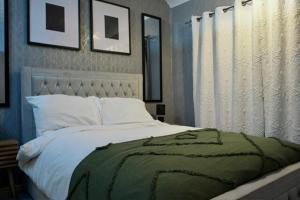 a bedroom with a bed with a green blanket on it at The Bank in West Derby