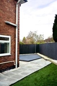 a backyard with a tennis court next to a brick building at The Bank in West Derby