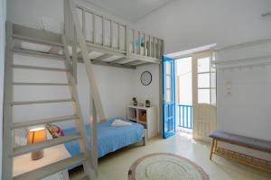 a small bedroom with a bunk bed and a ladder at Bougainvillea House in Parikia