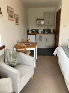 a living room with a couch and a table and a kitchen at Church Farm Hartham in Biddlestone