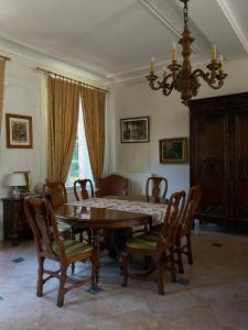 a dining room with a table and chairs and a chandelier at Château de Heuqueville in Heuqueville