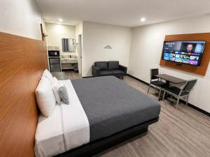 a hotel room with a bed and a flat screen tv at Scenic Motel - El Monte in El Monte