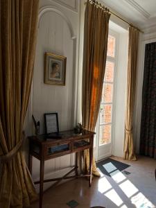 a room with a desk in front of a window at Château de Heuqueville in Heuqueville