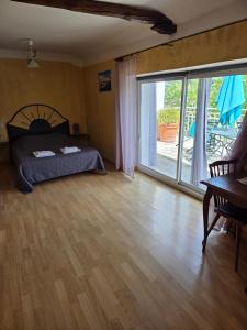 a bedroom with a bed and a large sliding glass door at Hotel Des Sites in Salavas