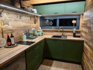 a kitchen with green cabinets and a sink at Sunny Garden House in Martinske Hole