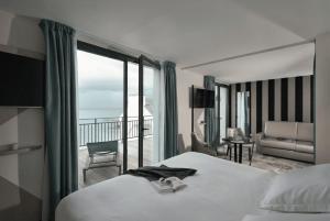a hotel room with a bed and a balcony at Hôtel la Baie Valdys Resort & SPA in Douarnenez