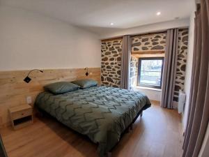 a bedroom with a bed in a room with a window at Maison en Auvergne - Chez Julien et Stephy in Celles