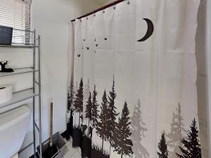 a bathroom with a shower curtain with trees on it at Mountain View Buck Deer Cabinette in Alto +9 photos