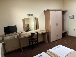 a room with a desk with a computer and a mirror at Семеен хотел МАКСИМ in Teteven