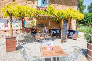 a group of people sitting at an outdoor restaurant at Les chalets de fiolles in Brens