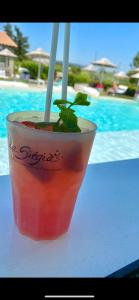 Ein Getränk steht auf einem Tisch neben einem Pool. in der Unterkunft La Siègià Resort spa in Massa Marittima + 115 Fotos