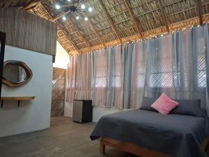 a bedroom with a bed and a mirror and a ceiling at Casa Xolococo in Brisas de Zicatela