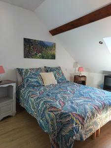 a bedroom with a bed with a colorful blanket at Le logis aux digitales in La Croix-aux-Mines