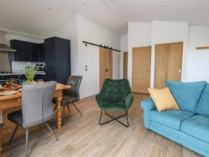 a living room with a blue couch and a table at Grass Roots in Temple Combe