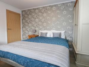 a bedroom with a large bed with blue and white sheets at Grass Roots in Temple Combe +10 photos