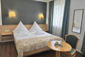 a bedroom with a bed and a table and a mirror at Grüner Baum in Bad Staffelstein +4 photos