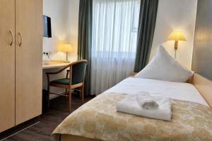 a hotel room with a bed and a desk at Grüner Baum in Bad Staffelstein