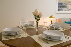 波多的住宿－西蒙賓客公寓，一张木桌,上面有盘子和玻璃杯,上面有鲜花