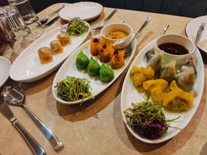 a table with plates of food and bowls of dips at Hotel Ember in Alwar