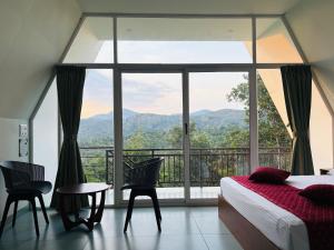 a bedroom with a bed and a large window at Wilmora in Ramakkalmedu