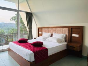 a bedroom with a bed with a large window at Wilmora in Ramakkalmedu