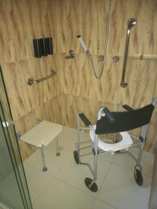 a shower with a chair in a bathroom at Hotel Pousada Ipitanga IV in Lauro de Freitas