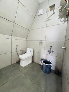 a bathroom with a toilet and a bucket in it at Wilmora in Ramakkalmedu