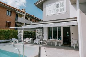 a patio with awning and tables and chairs next to a building at Riva Serena - Appartamento Oasi in Castelnuovo del Garda