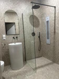 a bathroom with a shower with a sink and a toilet at Port Ostróda 3 - z widokiem na jezioro in Ostróda