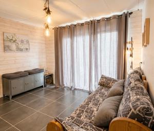 a living room with a couch and a large window at La Skibelle Orelle-ValThorens- Sauna & bain nordique in Orelle +14 photos