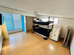 a room with two bunk beds and a wooden floor at K'sVILLAGE 平砂浦ハウスＳ in Tateyama