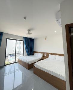 two beds in a room with a window at THANH THỦY HoTel in Hà Tiên +53 photos