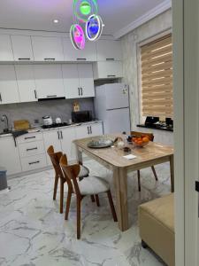 a kitchen with white cabinets and a wooden table and chairs at house for daily rent in Laza