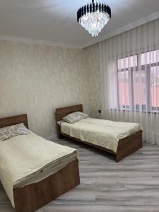 a bedroom with two beds and a chandelier at house for daily rent in Laza